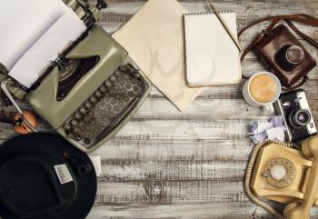Retro correspondent's desk and office items. Typewriter, blank newsprint to insert your mockup, coffee and camera