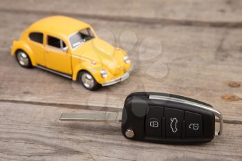 Toy car and key with remote alarm control on the wooden desk