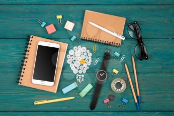 Idea concept - phone, watch, notepads, pencils and colorful office supplies