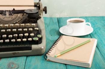 writer's workplace - wooden desk with vintage typewriter  and other supplies
