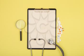 doctors workplace - medical tablet, stethoscope, pills and magnifying glass
