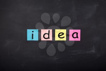 Business concept - Word 'Idea' written on color stickers on the chalkboard