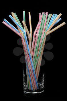 Color straw in glass isolated on the black background.