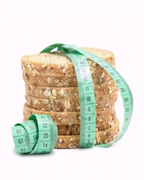 Fresh multigrain bread tied by green measuring tape - diet doncept.