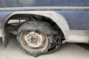Close-up image of torn tyre on old car.