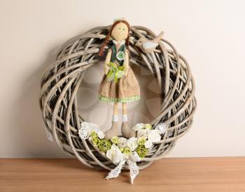 Interior decoration, wicker wreath with rose and doll.