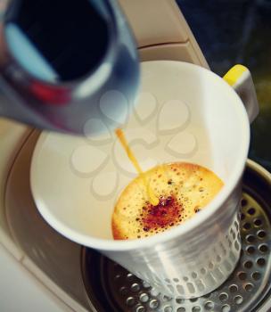 Closeup shot of an hot fresh espresso pouring to the cup  in espresso machine. Photo is in retro color style.