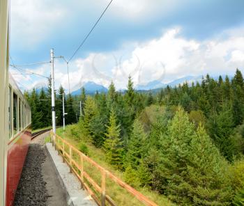 View of High Tatras mountains from window of speeding train on cog railway during way from Strba station to Strbske Pleso station.