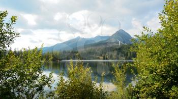 View of High Tatras mountains with ski jump from Strbske Pleso lake.