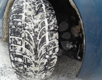 Close up of winter tire on snowy road. 