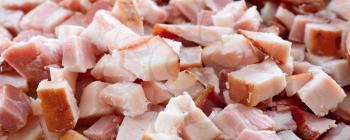 Closeup background with chopped bacon cubes.