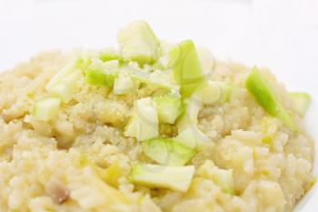 Portion of the Italian Risotto con zucchine with grated Parmesan and fresh pieces of zucchini.