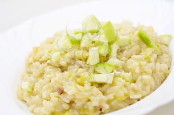 Portion of the Italian Risotto con zucchine with grated Parmesan and fresh pieces of zucchini.
