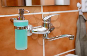 Closeup of a Soap Dispenser and Other Equipment in Bathroom.