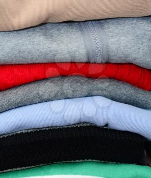 Stack of the multicolored falded clothes in the wardrobe.