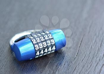 New blue metal combination lock on dark background.