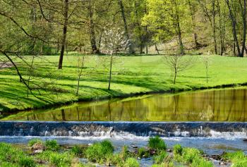 View of a river in the green park in a sunny day. Vlasim castle park.