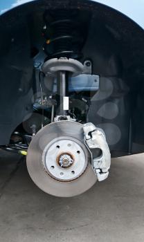 Close-up of a disc brake with caliper during tyre replacement. Car maintenance.