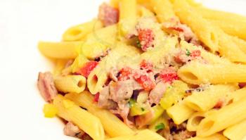 Close up of a penne with vegetable and pieces of bacon sprinkled with parmesan cheese.