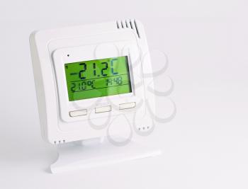 Remote home interior thermostat controller over white background.
