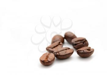 Group of coffee beans on white background with copy space on left.