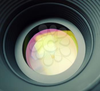 Closeup of aperture in camera lens with light reflection effect.