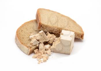 Fresh yeast block crumbled on two slices of bread over white background.