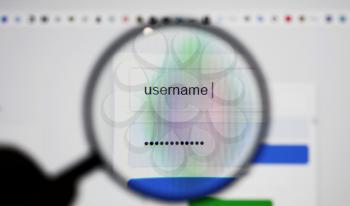 View through a magnifying glass on login page screen with username and password box in internet browser.