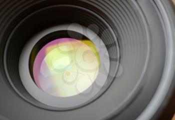 Closeup of aperture in camera lens with light reflection effect.