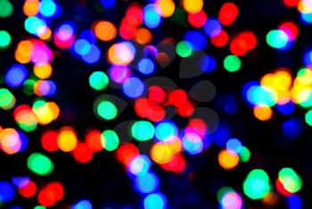 Blurred glittering christmas LED multi color lights, circle color bokeh on dark background.