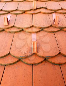 Full frame closeup of orange roof with orange tiles with snow guard.