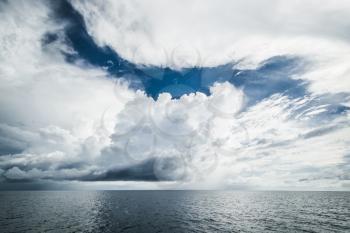 Dark clouds in open ocean. Tropical hurricane and sea storm