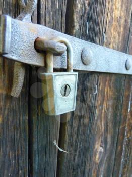 Close up detail of old vintage padlock lock hanging on the door.