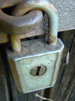 Close up detail of old vintage padlock lock hanging on the door.