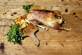 Roasted goose on wooden table