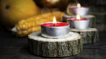 Burning Candles With Pumpkins, Corncob, autumn leaves in the background. Thanksgiving Day, Decoration on a wooden table