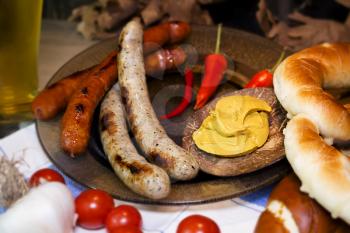 Bavarian White And Red Sausages With Mustard, Bavarian Buns and Pretzels At The Table. October Fest Concept
