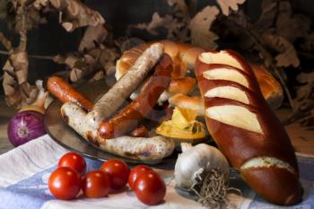Bavarian White And Red Sausages With Mustard, Bavarian Buns and Pretzels At The Table. October Fest Concept