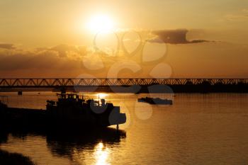 Beautiful Golden Sunset with Ships and Bridge Silhouettes At The River Danube in Belgrade Serbia
