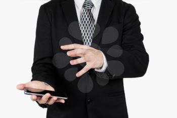 Businessman in Back Suit and Tie Holding Smartphone in Hand With Hand Gesture Over The Phones Screen Against White Background