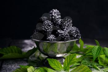 Blackberries Served With Sprinkled Powdered Sugar and Blackberry Leaves On Rustic Wooden Table