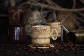 Vintage Coffee Cup, Pot, Grinder With Coffee Beans On a Rustic Wooden Surface
