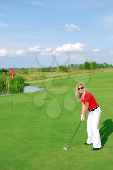 Blonde girl golf player on golf field