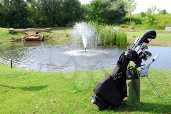 Golf bag with clubs and water behind