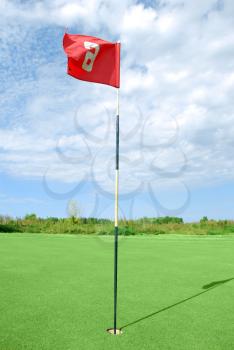 Golf field with golf red flag