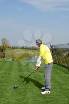 Male golf player preparing for hit