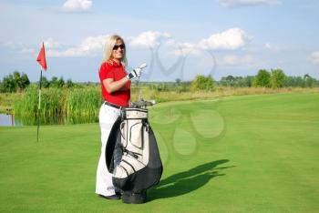 Beauty girl with golf bag on golf course