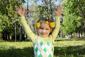 happy little girl in park with hand up