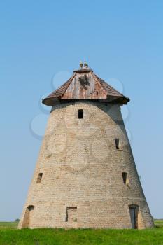 old windmill with stork nest on roof