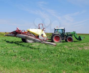 Tractor with sprayer on field